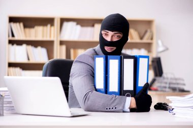 Suçlu iş adamı ofiste kar maskesi giyiyor.