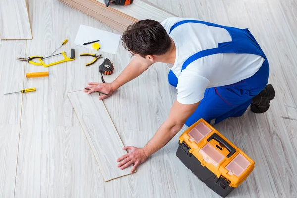 Reparador que estabelece piso laminado em casa — Fotografia de Stock