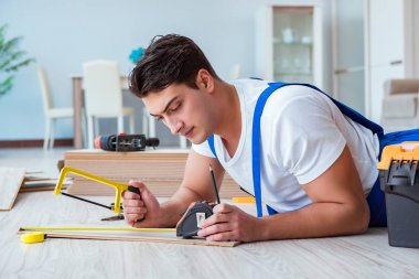 Tamirci evde döşeme kaplaması döşemiş.