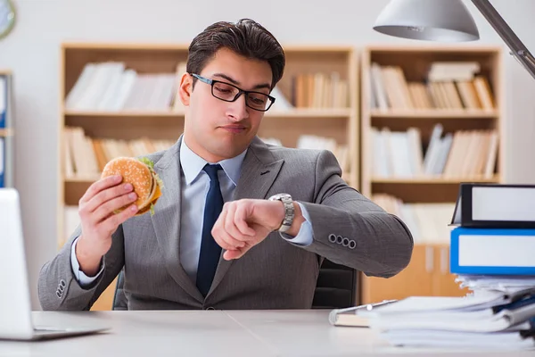 Голодные веселые бизнесмены едят сэндвичи с нездоровой едой — стоковое фото