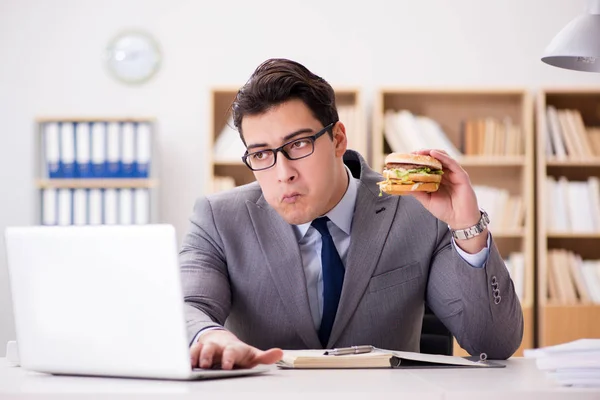 Hongerige grappige zakenman die junk food sandwich eet — Stockfoto