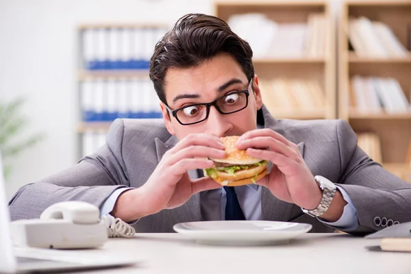 Hambriento empresario divertido comer sándwich de comida chatarra —  Fotos de Stock