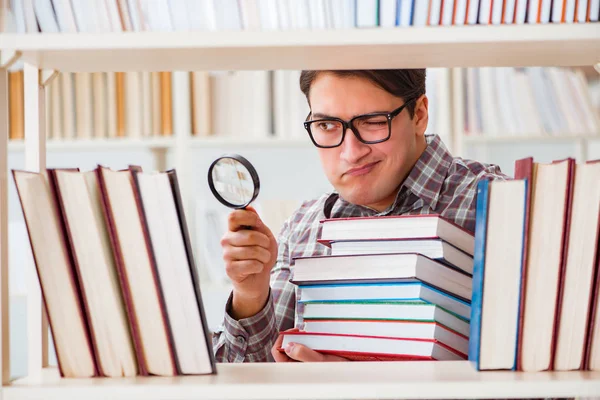 Jovem estudante procurando livros na biblioteca da faculdade — Fotografia de Stock