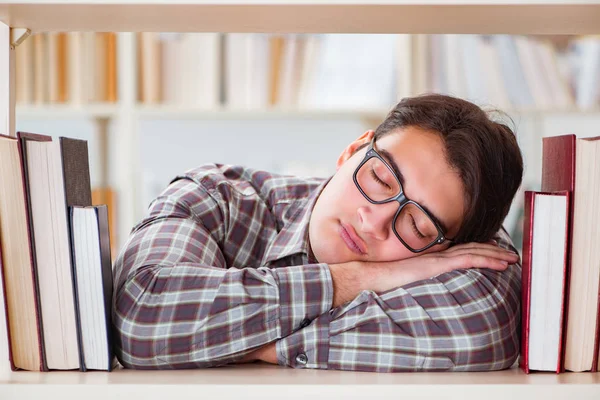 Joven estudiante en busca de libros en la biblioteca universitaria — Foto de Stock