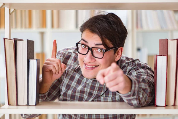 Jonge student op zoek naar boeken in universiteitsbibliotheek — Stockfoto