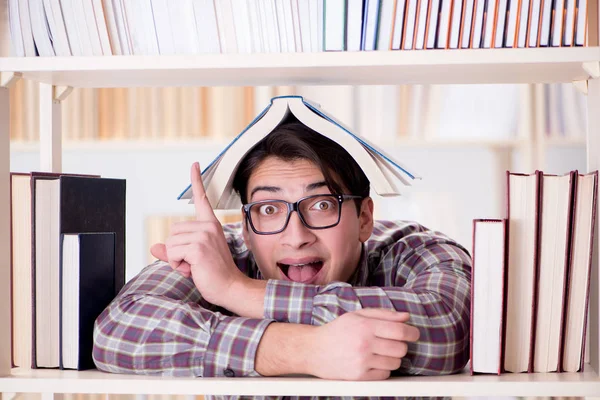 Jovem estudante procurando livros na biblioteca da faculdade — Fotografia de Stock