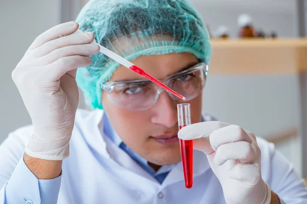 Jonge arts werkt aan bloedonderzoek in het lab ziekenhuis — Stockfoto