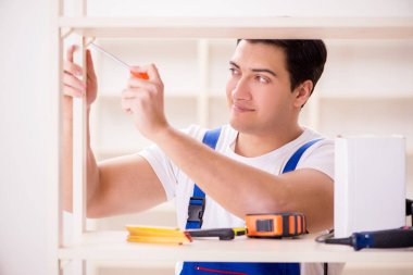 İşçi adam montaj kitaplığını tamir ediyor