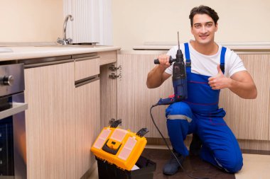 Mutfakta çalışan genç tamirci.