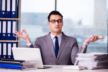 İşadamı ofiste meditasyon yapıyor.