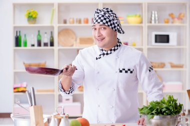 Genç aşçı mutfakta çalışıyor.