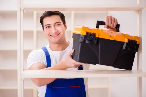 Arbeiter repariert Bücherregal — Stockfoto