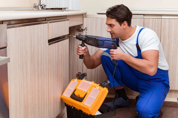 Jonge reparateur werkt in de keuken — Stockfoto