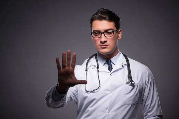 Joven médico contra fondo oscuro — Foto de Stock