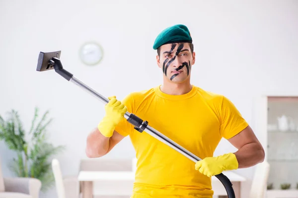 Hombre gracioso en estilo militar limpiando la casa — Foto de Stock