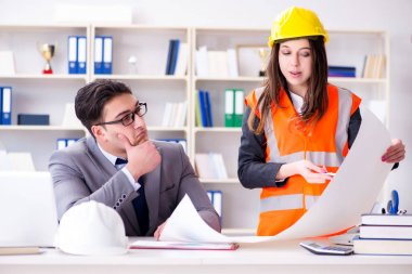 İnşaat ustabaşı çizimleri gözden geçiriyor