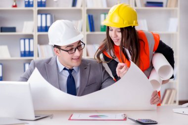 İnşaat ustabaşı çizimleri gözden geçiriyor