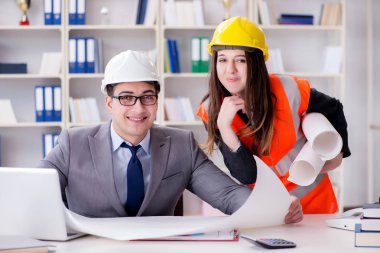 İnşaat ustabaşı çizimleri gözden geçiriyor