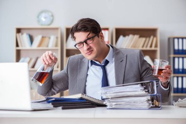 İş adamı ofiste içiyor.