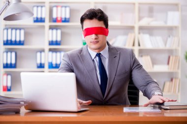 Ofiste masasında oturan gözü bağlı iş adamı.