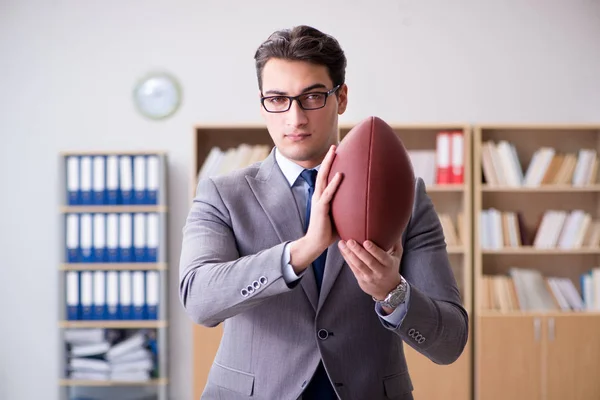 Empresario con fútbol americano en la oficina — Foto de Stock