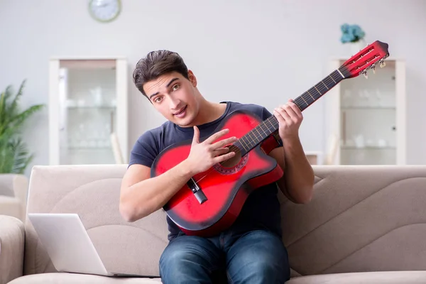 Joven practicando la guitarra en casa — Foto de Stock