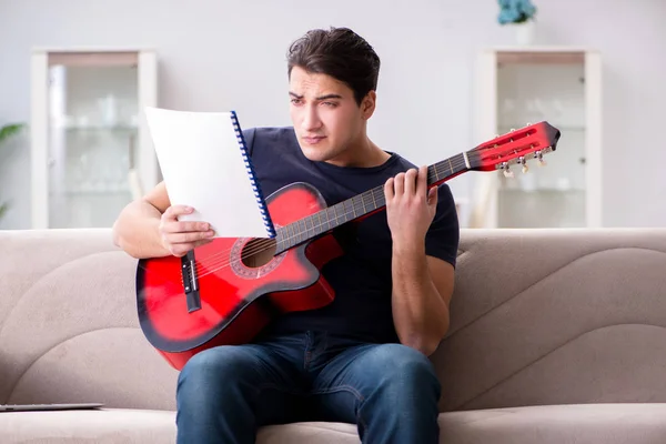 Joven practicando la guitarra en casa — Foto de Stock