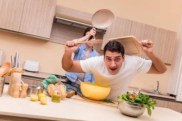 Jovem família fazendo luta engraçada na cozinha — Fotografia de Stock