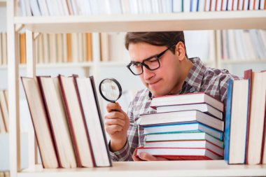 Üniversite kütüphanesinde kitap arayan genç bir öğrenci.