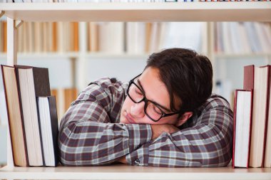 Üniversite kütüphanesinde kitap arayan genç bir öğrenci.