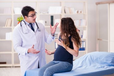 Doktor hamile kadını muayene ediyor.