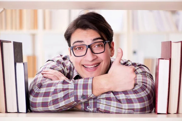 Jeune étudiant à la recherche de livres dans la bibliothèque du collège — Photo