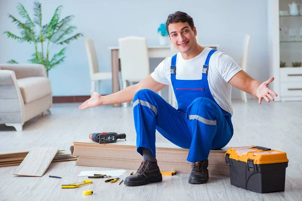 Reparador que estabelece piso laminado em casa — Fotografia de Stock