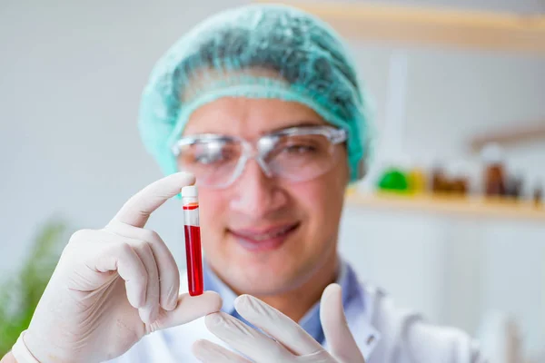 Młody lekarz prowadzący badania krwi w szpitalu laboratoryjnym — Zdjęcie stockowe