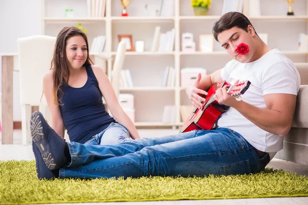 Pareja romántica tocando la guitarra en el suelo — Foto de Stock