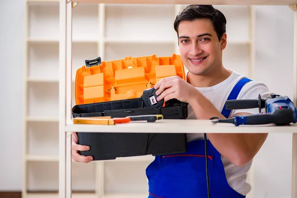 Trabalhador reparando montagem estante de livros — Fotografia de Stock