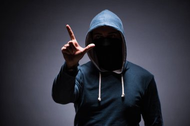Karanlık odada kaputu giyen adam