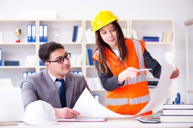 İnşaat ustabaşı çizimleri gözden geçiriyor