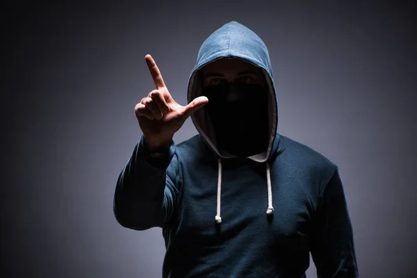 Man wearing hood in dark room — Stock Photo, Image