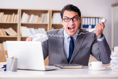 Ofiste çok işi olan kızgın bir işadamı.