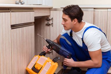 Mutfakta çalışan genç tamirci.