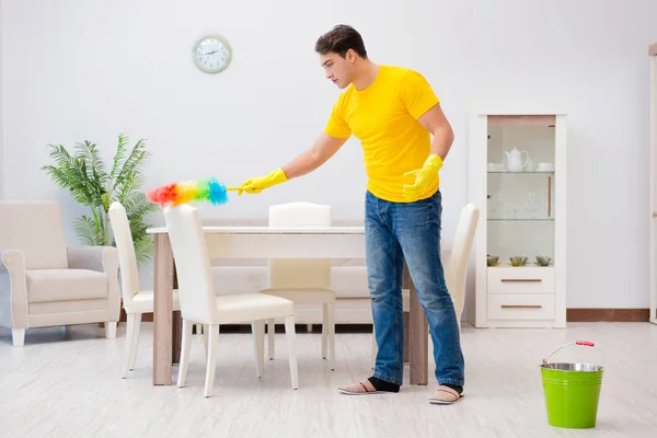 Een man die het huis schoonmaakt en zijn vrouw helpt — Stockfoto