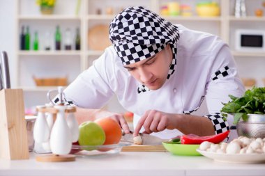 Genç aşçı mutfakta çalışıyor.