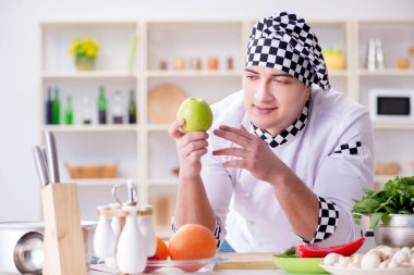 Genç aşçı mutfakta çalışıyor.