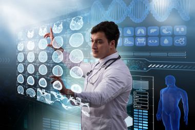Erkek doktor MRI taramasının röntgenini çekiyor.