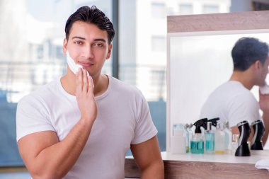 Genç yakışıklı adam sabahları tıraş oluyor.