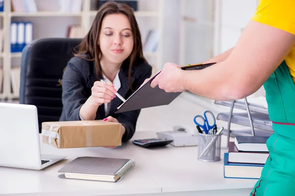 Postbode bezorgt pakketje op kantoor — Stockfoto