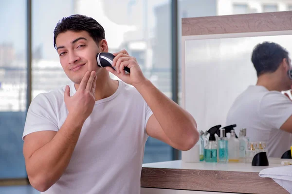 Joven hombre guapo afeitándose por la mañana — Foto de Stock