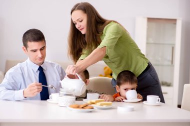 Mutlu bir aile evde kahvaltı yapıyor.