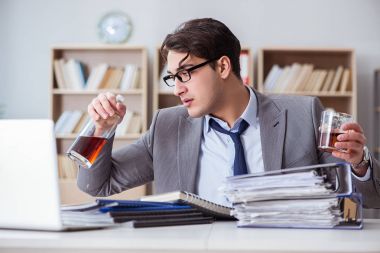 İş adamı ofiste içiyor.